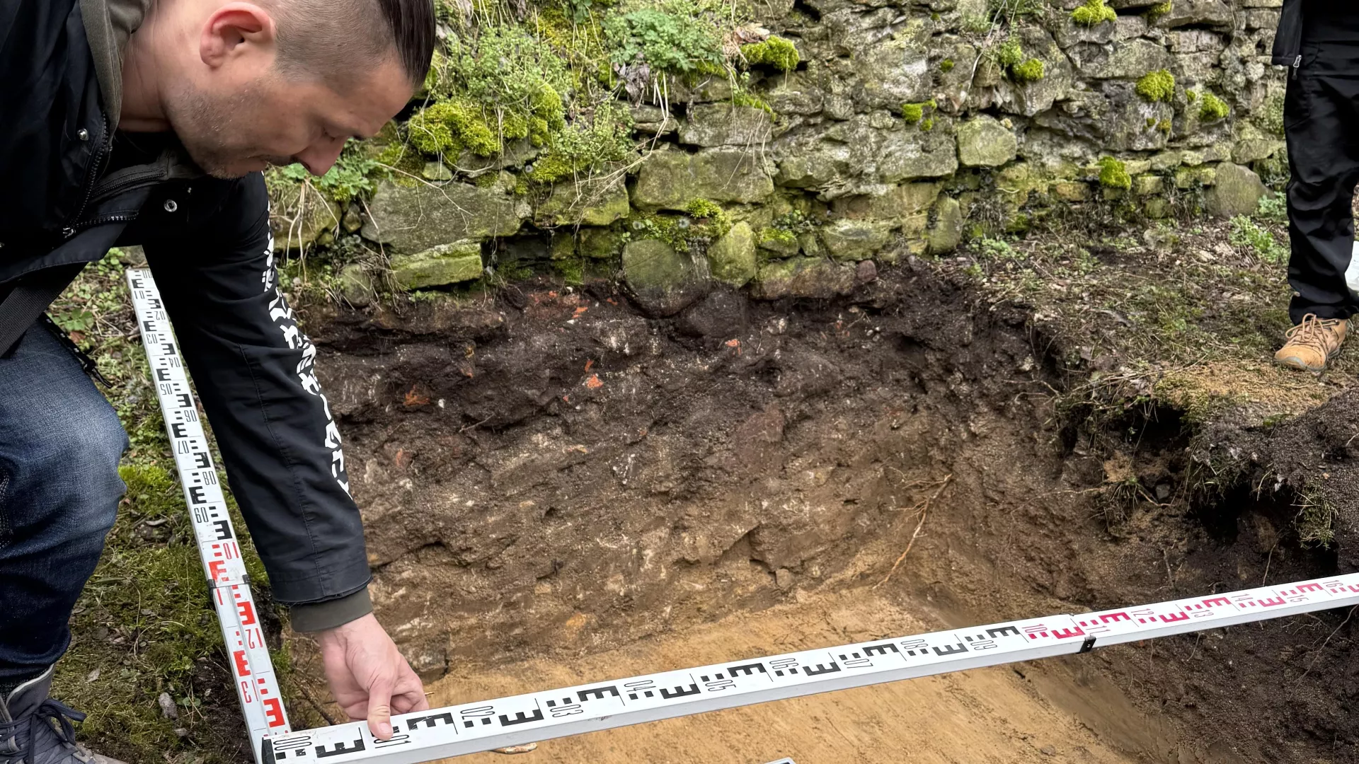 Pomiary wykopu archeologicznego przy murach zamku w Dankowie.