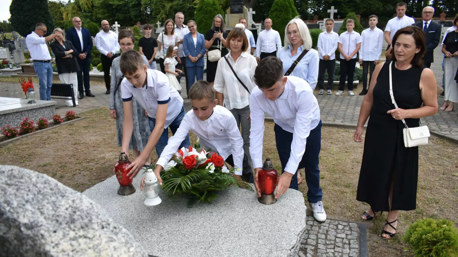 Dzieci składają znicze na grobie zamordowanego przez Niemców ks. Bonawentury Metlera.