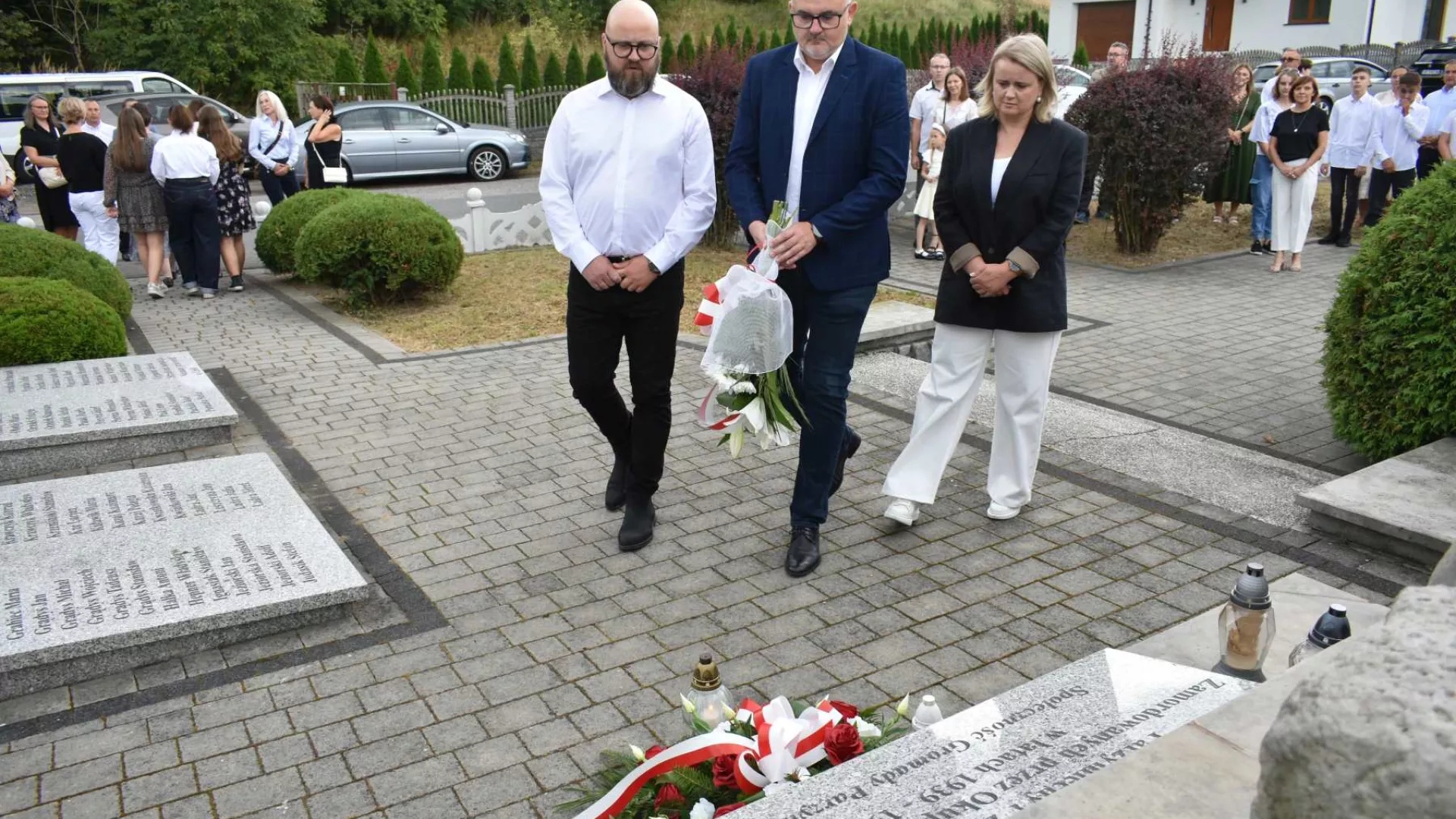 Delegacja rady sołeckiej Parzymiech składa kwiaty pod pomnikiem cywilnych ofiar wojny.