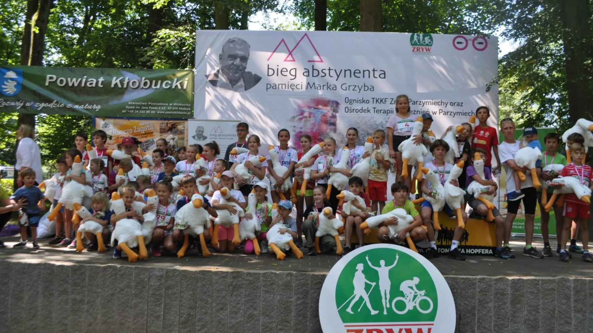 Na scenie dzieci uczestnicy biegów na dystansach dziecięcych z otrzymanymi maskotkami.