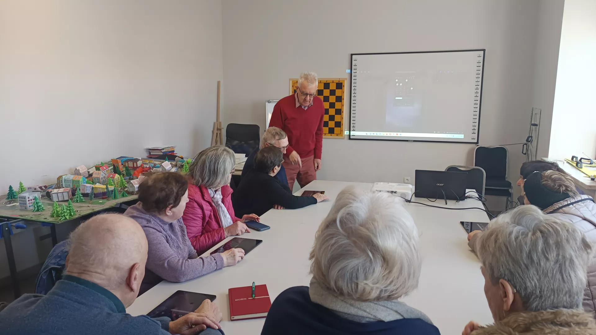 Uczestnicy zajęć podczas pracy z tabletami w czasie zajęć edukacyjnych z informatyki w klubie seniora w Zimnowodzie.