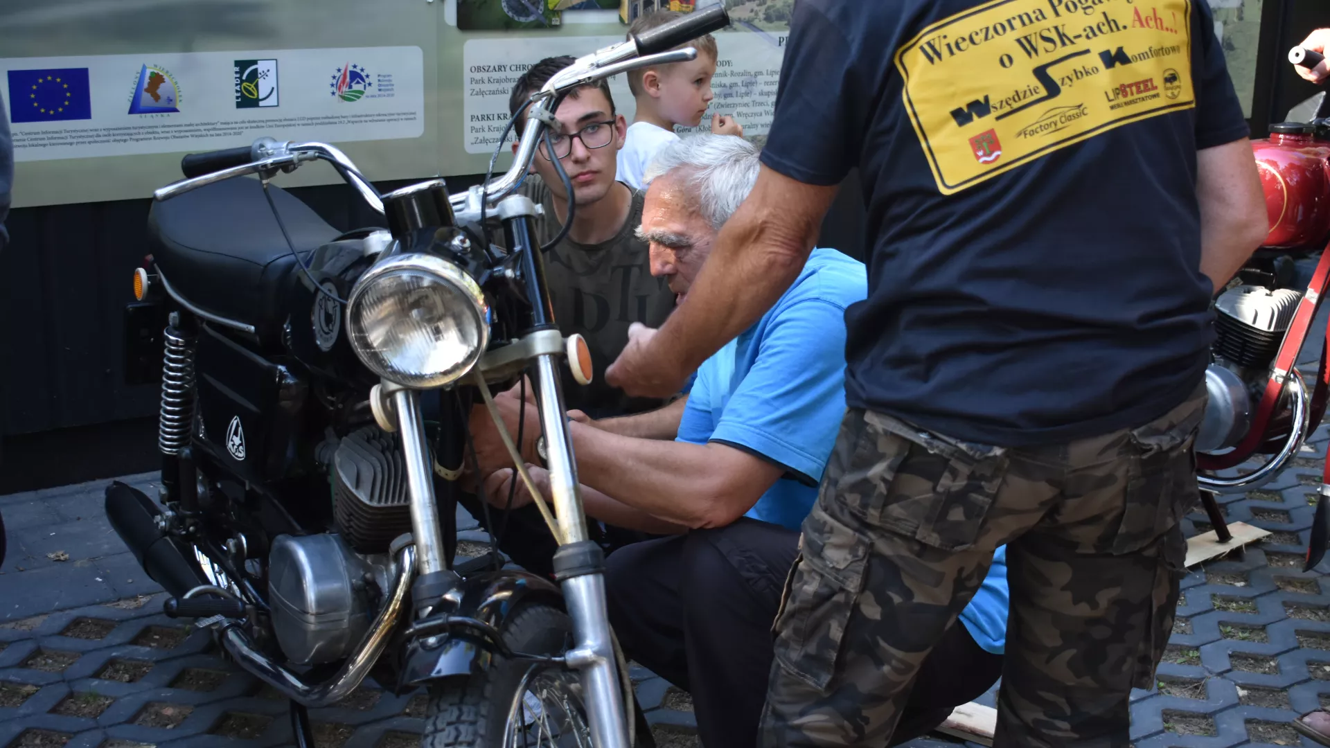 Uczestnicy zlotu WSK naprawiający motocykl