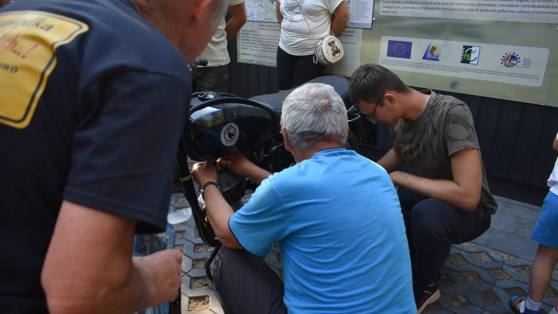 Uczestnicy zlotu WSK naprawiający motocykl