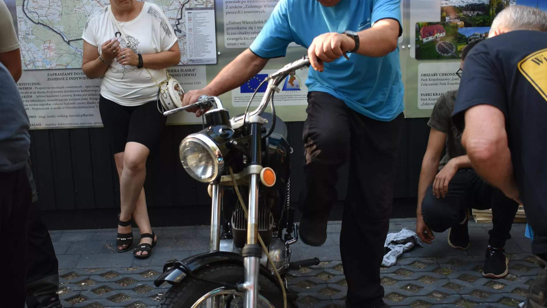 Uczestnicy zlotu WSK naprawiający motocykl