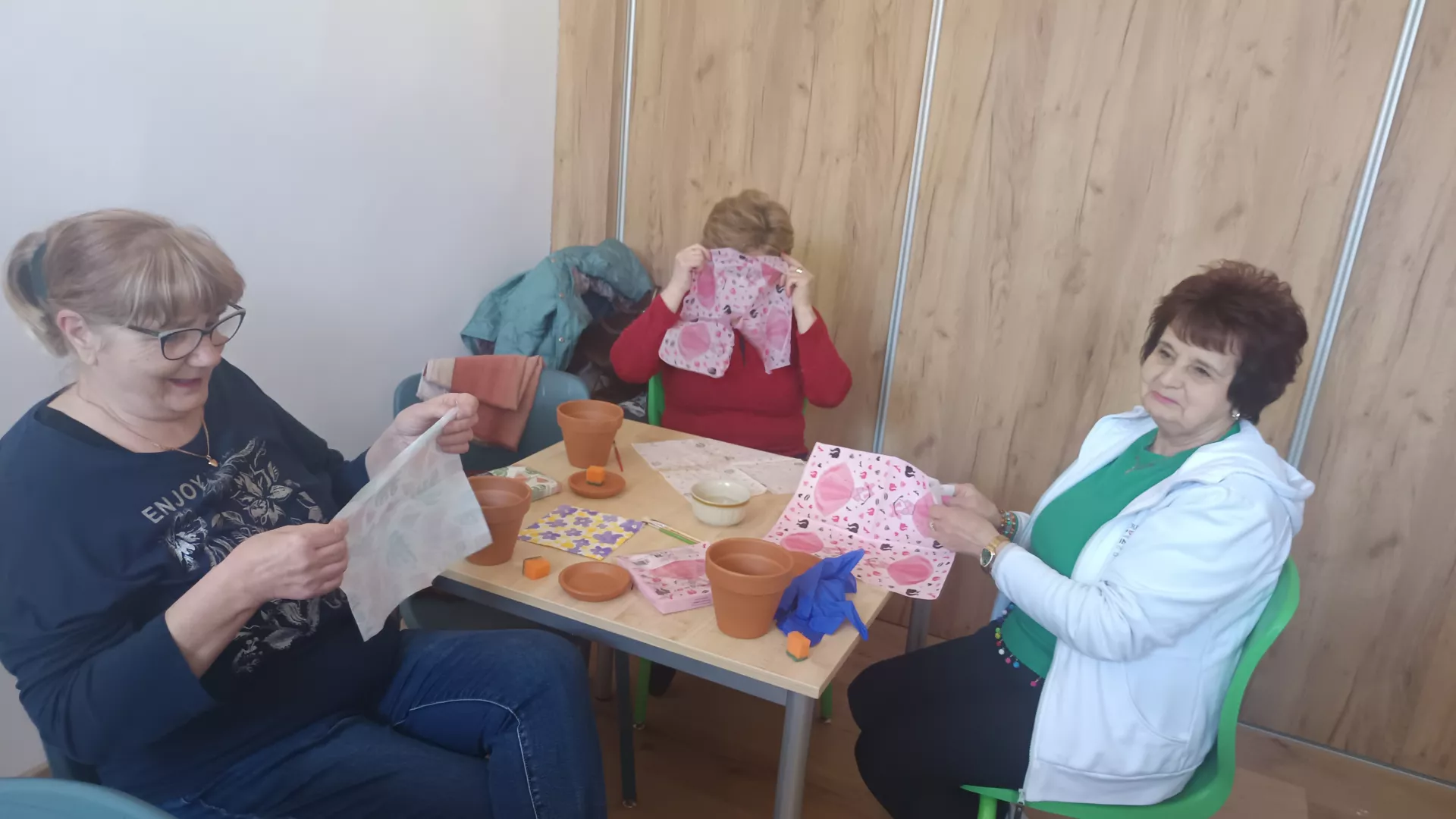 Uczestnicy zajęć podczas dekorowanie doniczek metodą decoupage w czasie zajęć z animatorem w klubie seniora w Lipiu.