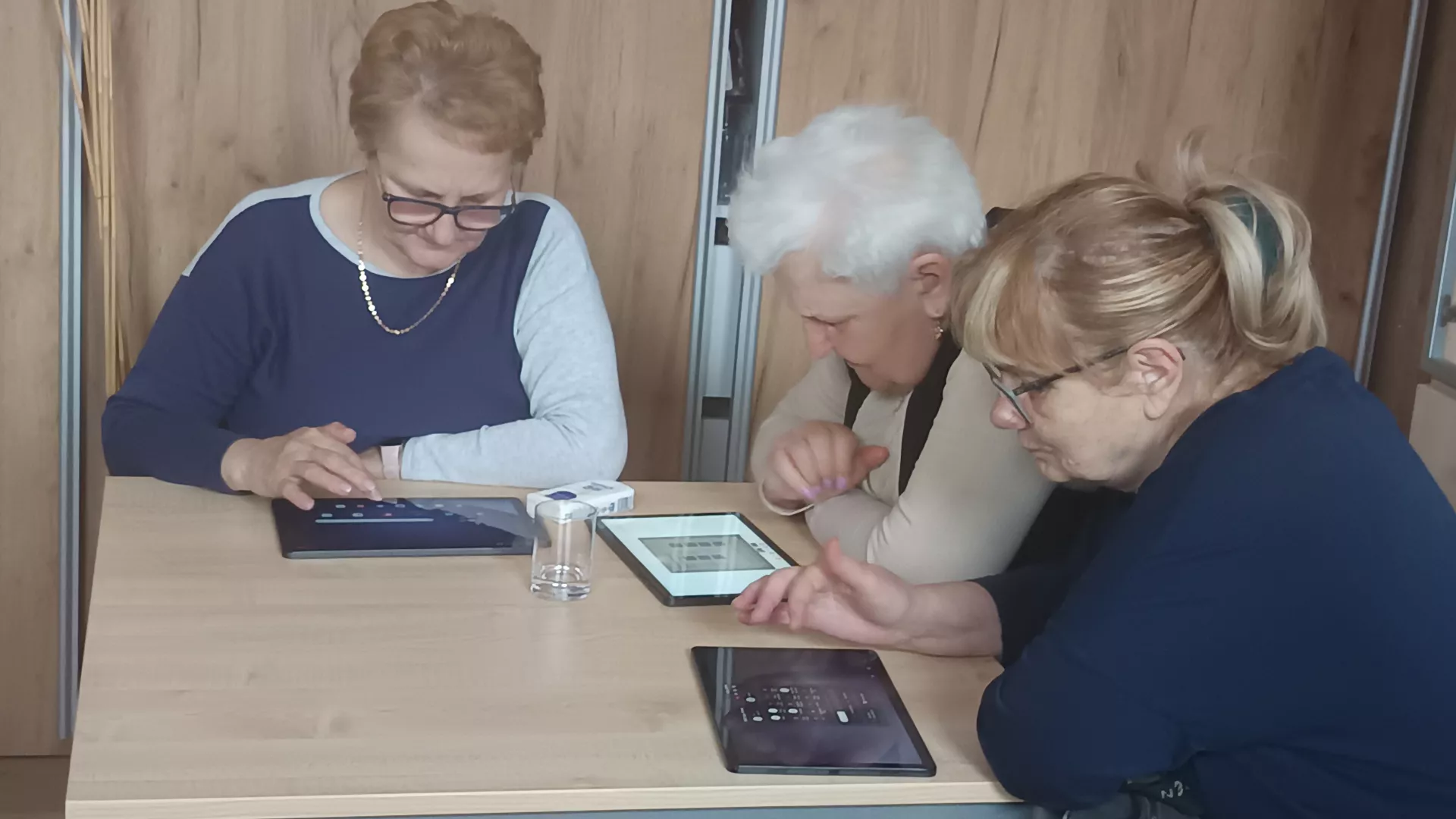 Uczestnicy zajęć podczas pracy z tabletami w czasie zajęć edukacyjnych z informatyki w klubie seniora w Lipiu.