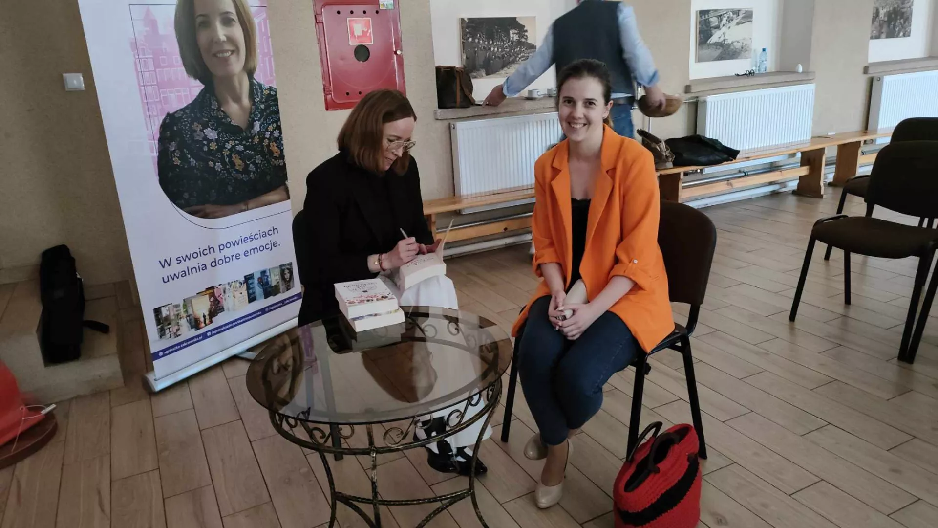 Autorka podpisuje książki zakupione przez uczestników spotkania