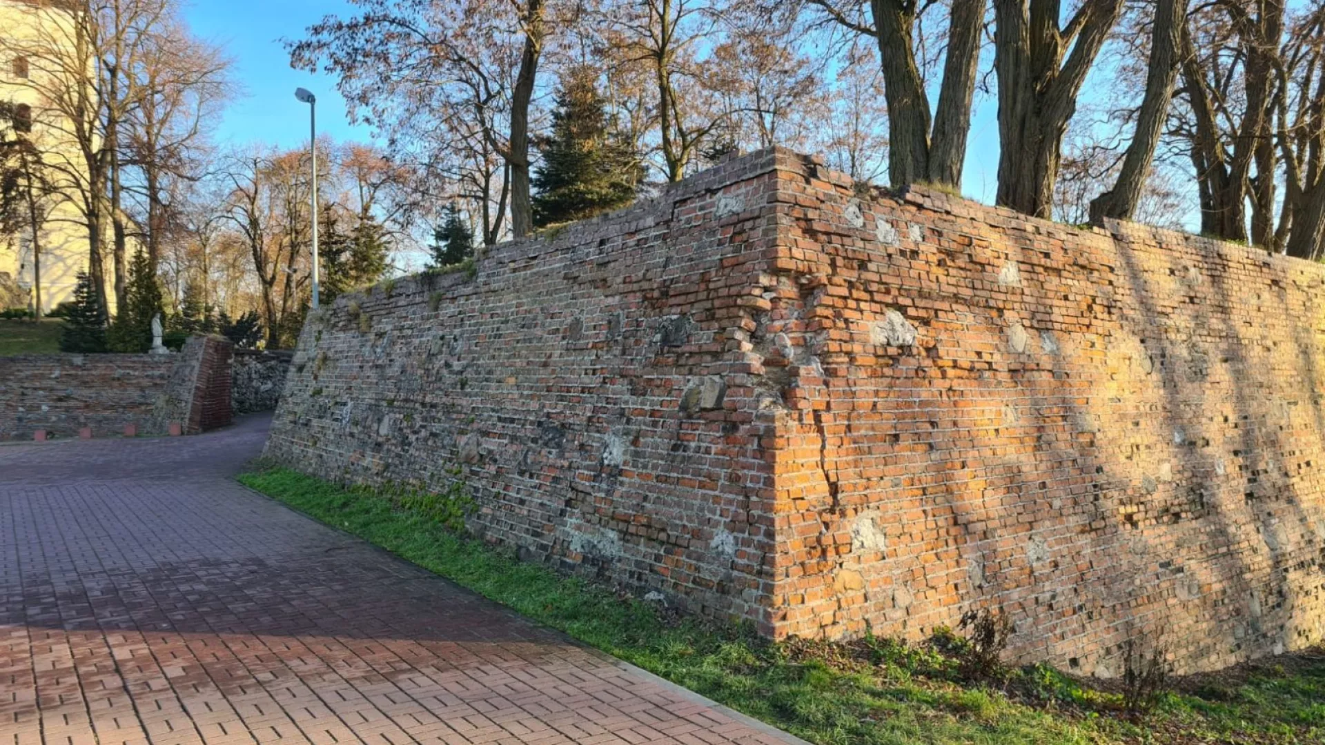 Fragment obwarowań wokół sanktuarium w Dankowie, w tle widoczny kościół.