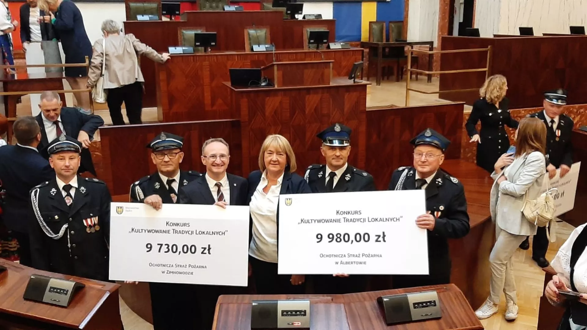 Przedstawiciele OSP Albertów i OSP Zimnowoda oraz wiceprzewodnicząca Rady Gminy Lipie Alicja Podgórska wraz z członkiem Zarządu Województwa Śląskiego Grzegorzem Boskim trzymają symboliczne czeki z kwotami przyznanych dotacji.