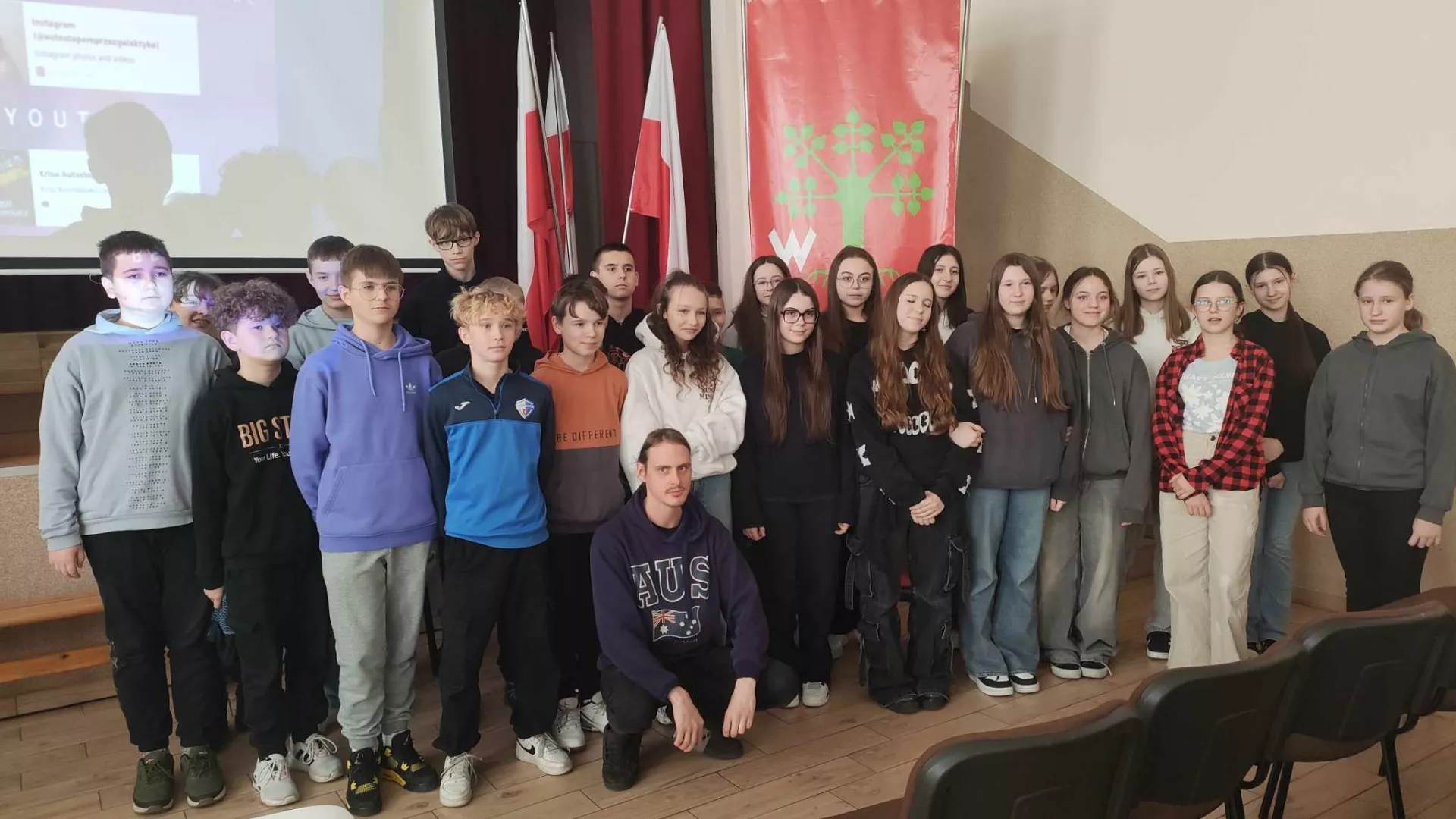 Grupowa fotografia uczestników spotkania i podróżnika.