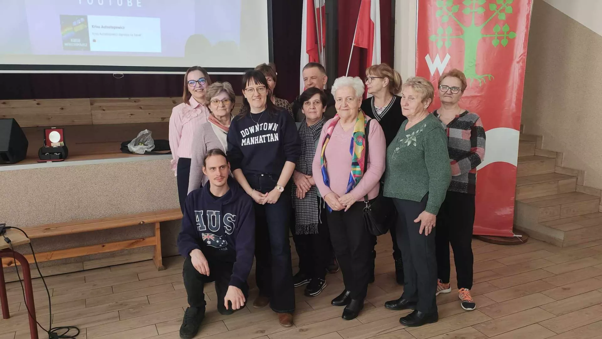 Grupowa fotografia uczestników spotkania i podróżnika.