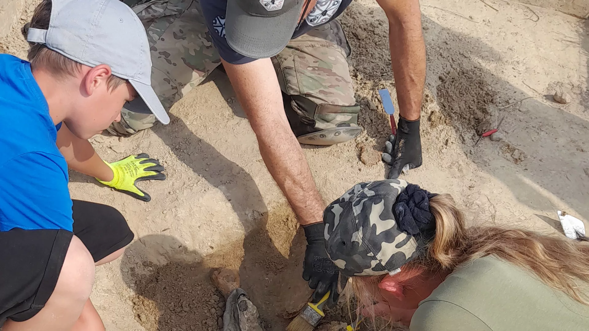 Archeolodzy starannie odsłaniają i wydobywają z ziemi znalezisko.