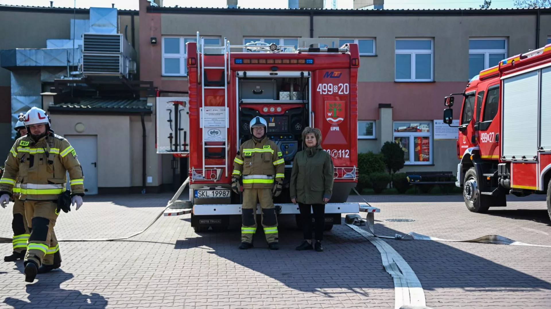 Wójt Gminy Lipie i strażacy na tle samochodów strażackich podczas ćwiczeń w ZS-P Lipie