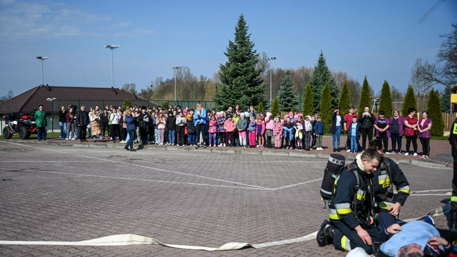 Strażacy udzielający pierwszej pomocy osobom poszkodowanym oraz ewakuowani uczniowie, nauczyciele i pracownicy obsługi w ZS-P Lipie