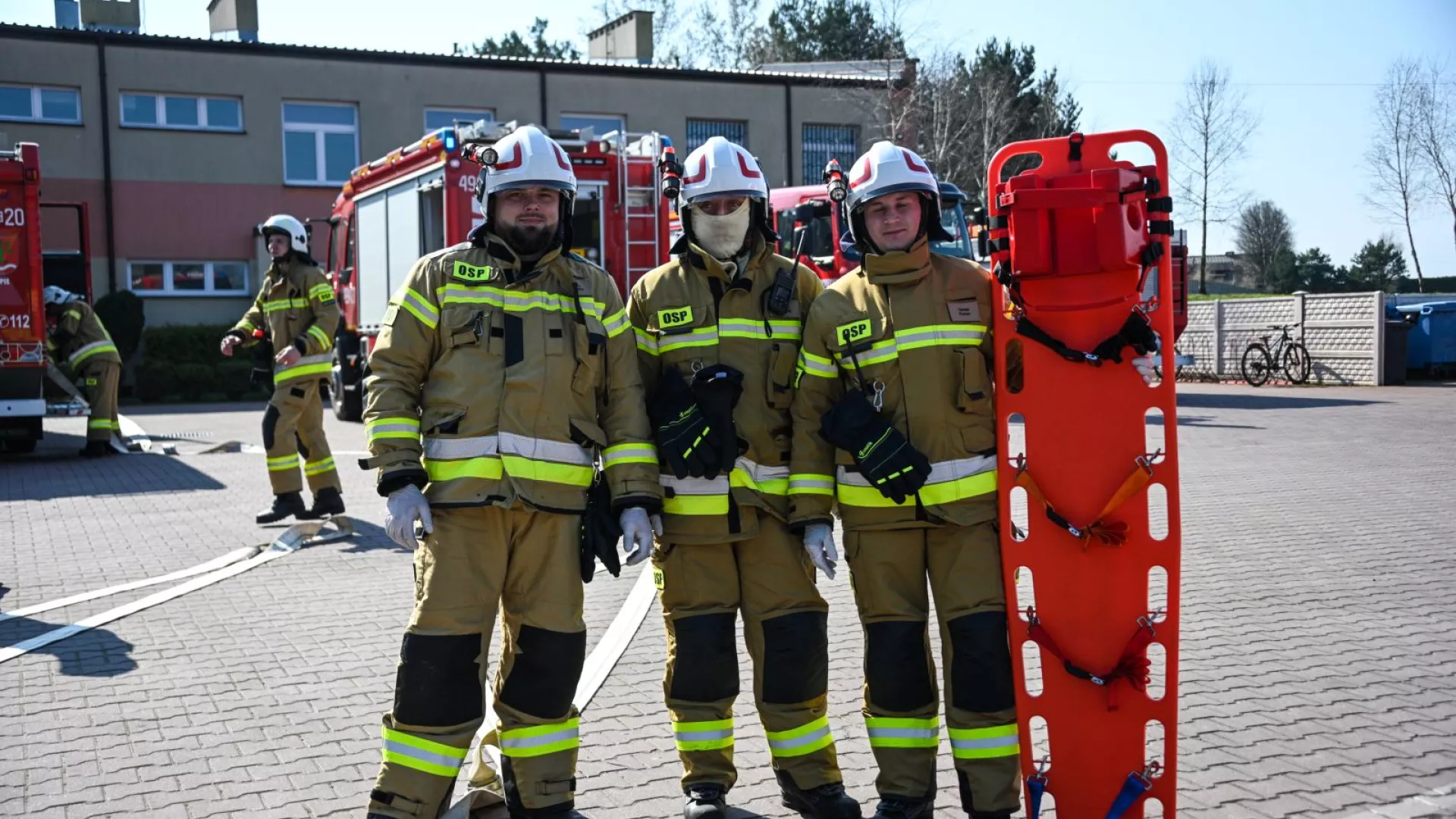 Strażacy z OSP Zbrojewsko na tle samochodów strażackich