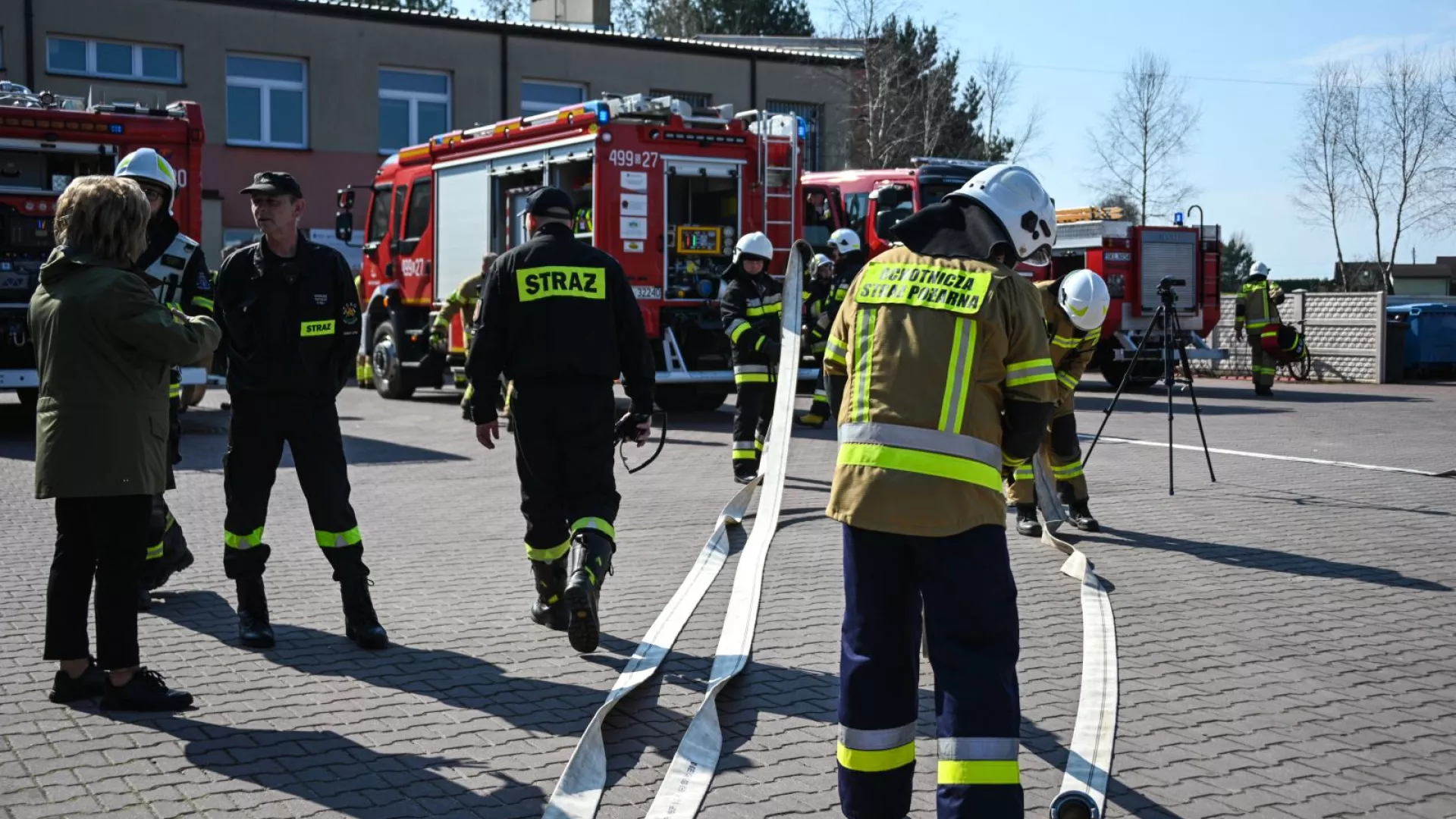 Wójt Gminy Lipie i strażacy na tle samochodów strażackich podczas ćwiczeń w ZS-P Lipie