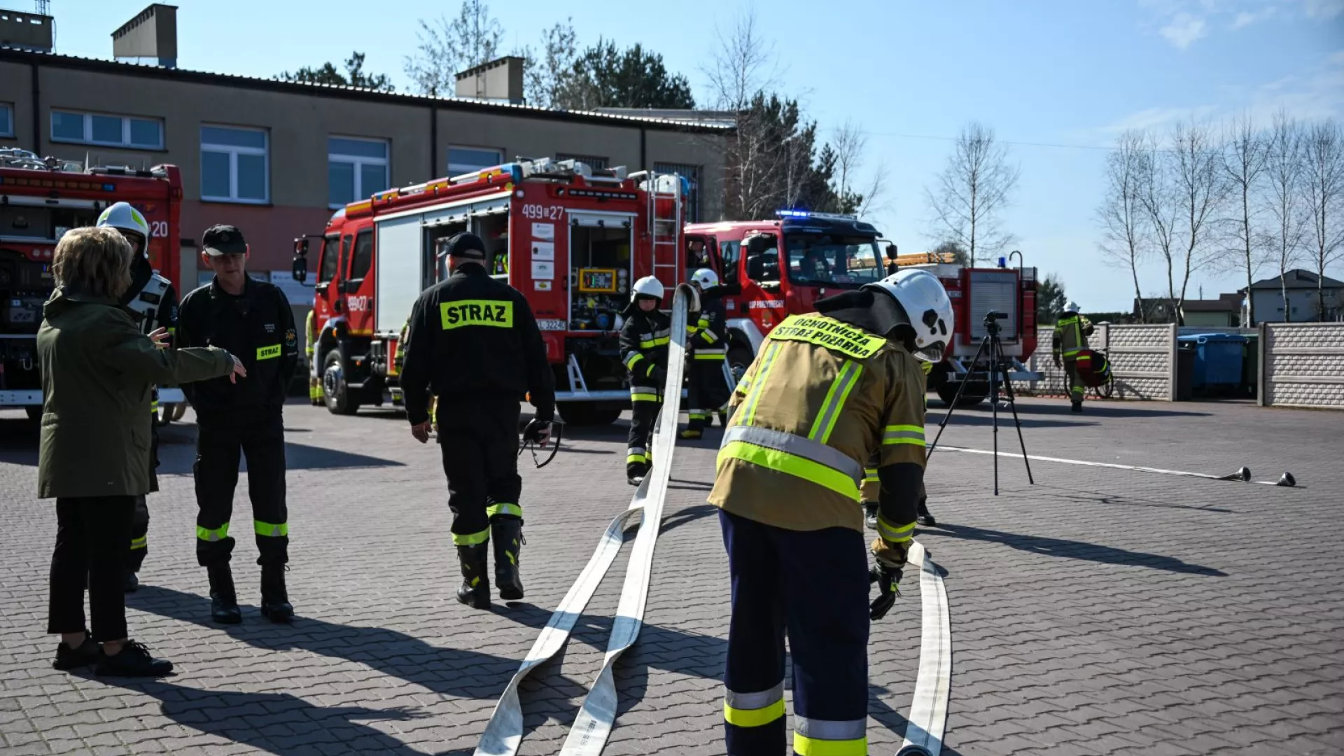 Wójt Gminy Lipie i strażacy na tle samochodów strażackich podczas ćwiczeń w ZS-P Lipie