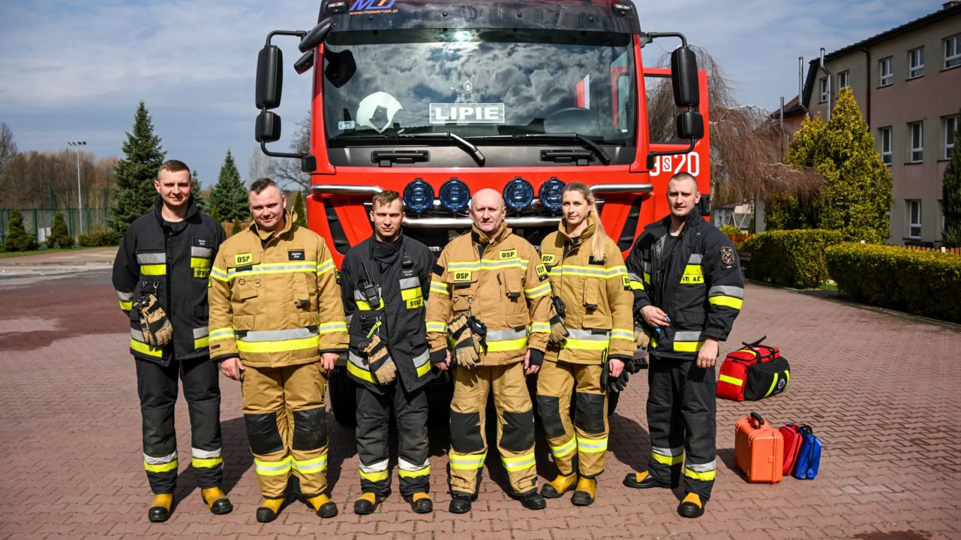 Strażacy OSP Lipie na tle samochodu strażackiego