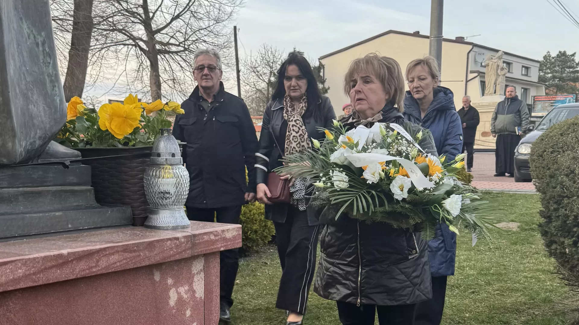 symboliczne złożenie kwiatów i zniczy pod pomnikiem św. Papieża Polaka