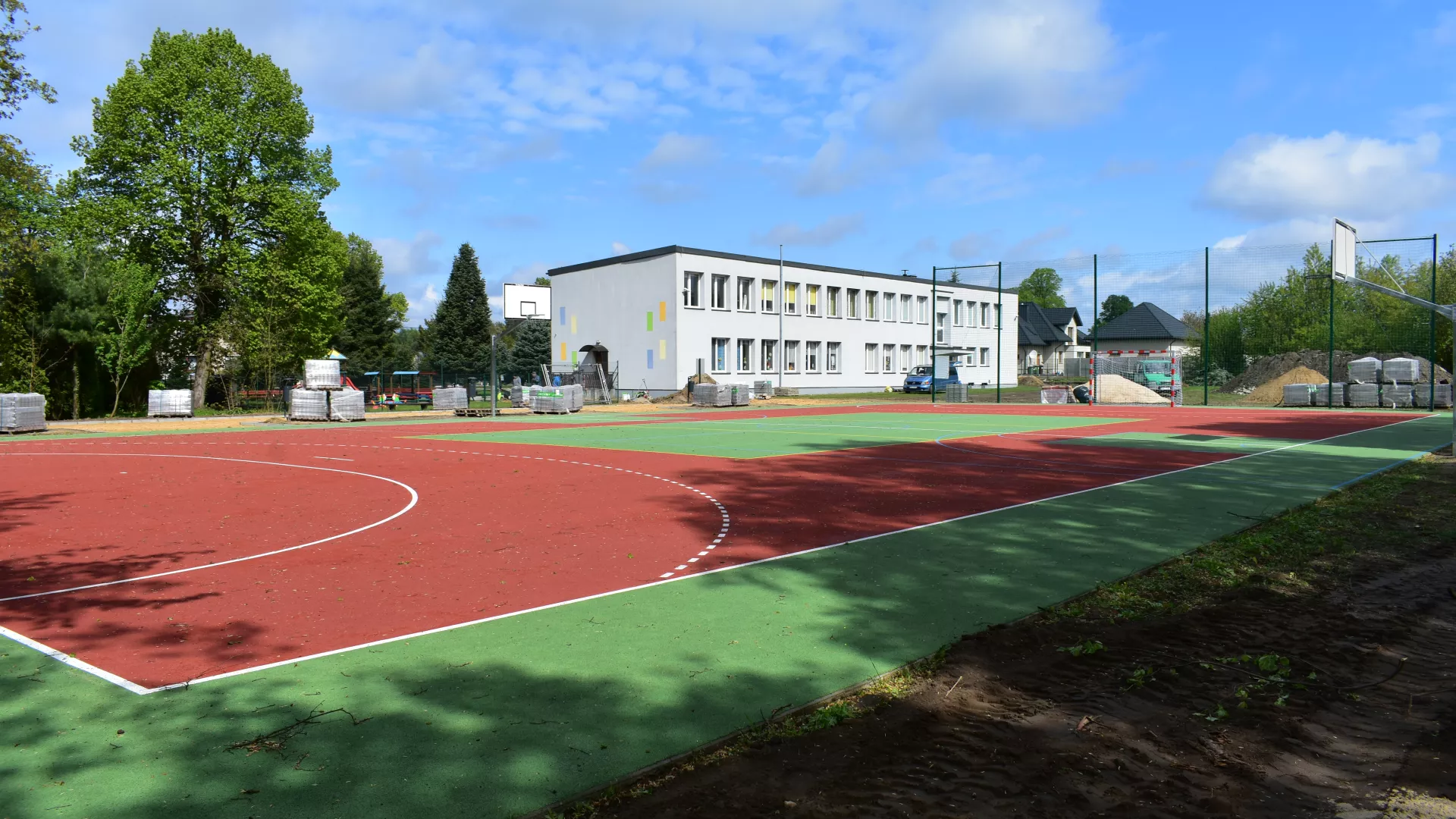 Boisko w Lindowie obok budynku szkoły i realizowane prace przy budowie drogi.