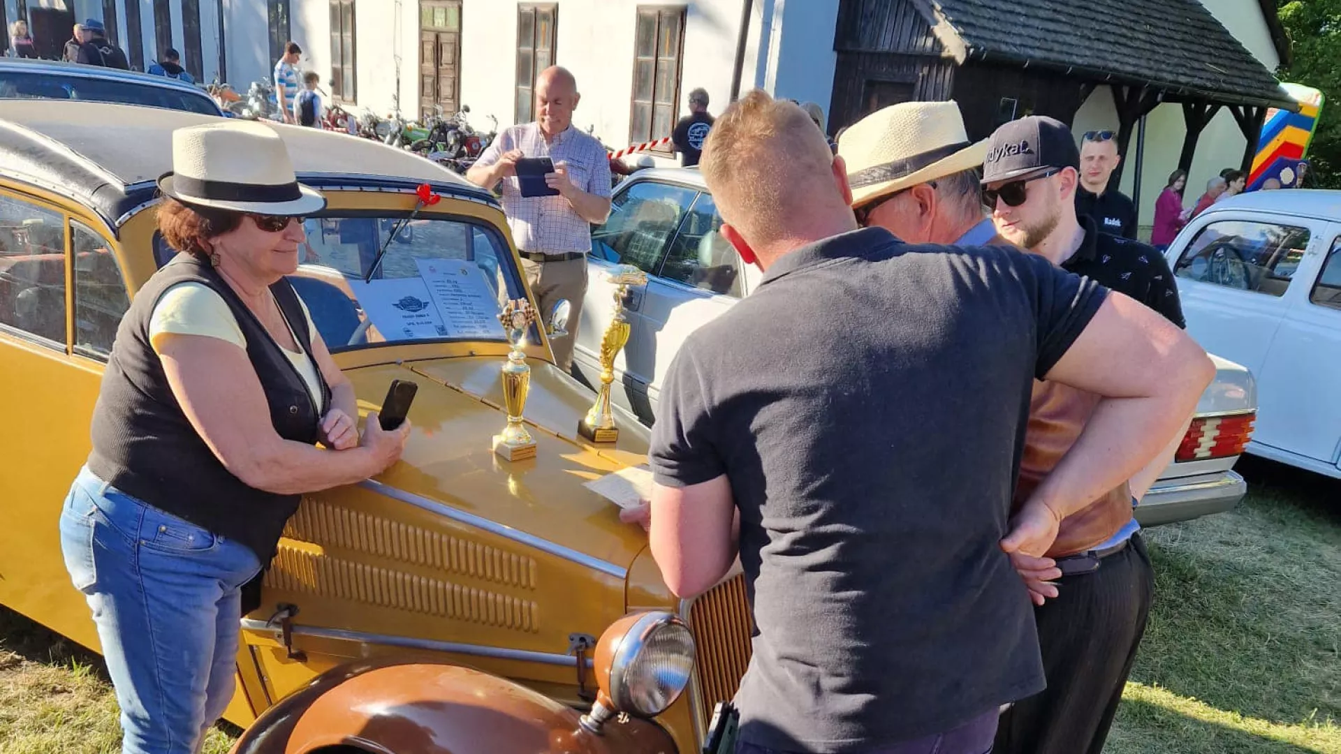 Pasjonaci starej motoryzacji przy jednym z zabytkowych pojazdów.