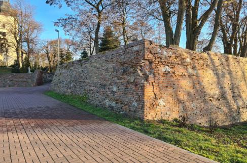 Fragment obwarowań wokół sanktuarium w Dankowie, w tle widoczny kościół.