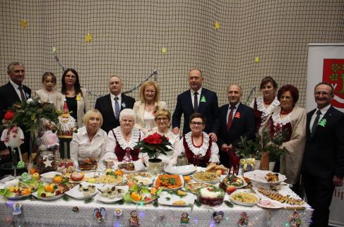 Wspólna fotografia KGW Lipie i honorowych gości prezentacji przy stole bożonarodzeniowym