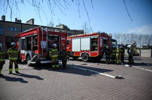 Wójt Gminy Lipie i strażacy na tle samochodów strażackich podczas ćwiczeń w ZS-P Lipie