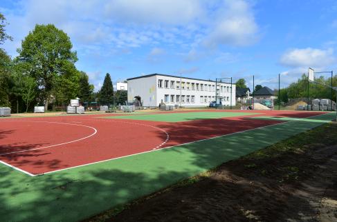 Boisko w Lindowie obok budynku szkoły i realizowane prace przy budowie drogi