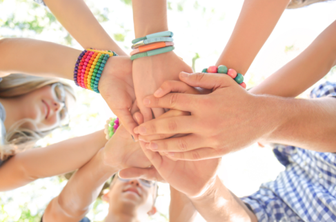 Plakat 1 przedstawia złączone w przyjacielskim uścisku dłonie dzieci.