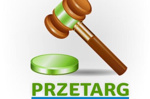 Drewniany młotek uderzający z zielona podstawkę oraz napis przetarg