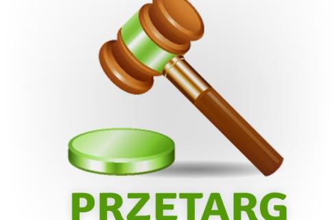 Drewniany młotek uderzający z zielona podstawkę oraz napis przetarg