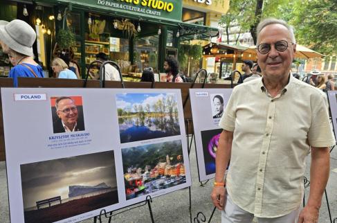 Krzysztof Muskalski przy swoich fotografiach na wystawie w Wietnamie
