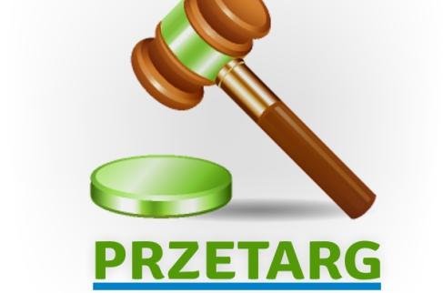 Drewniany młotek uderzający z zielona podstawkę oraz napis przetarg